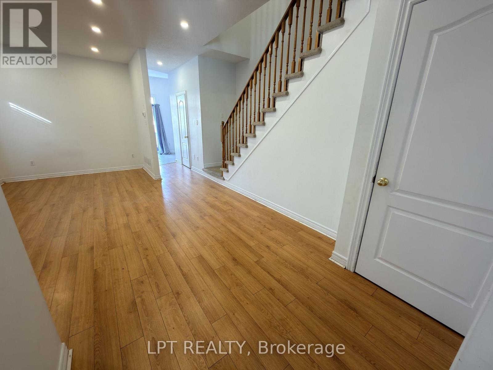 A hallway with wooden floors and white walls.