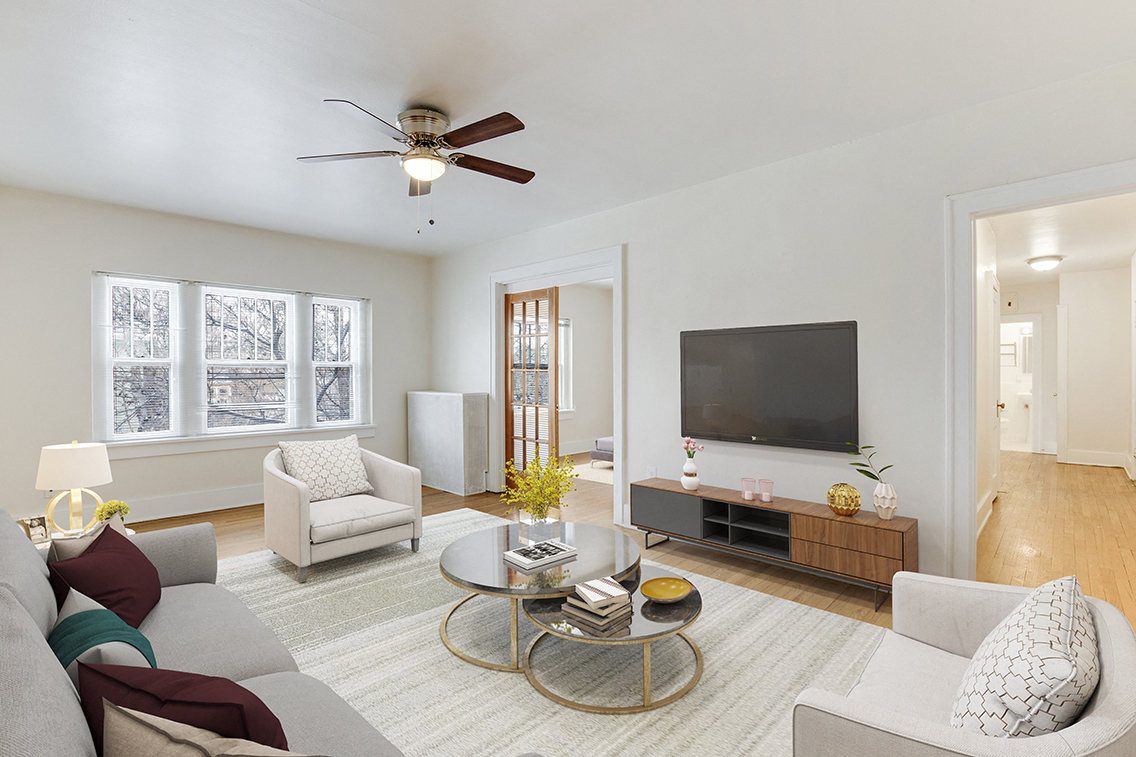 a living room with a ceiling fan and a tv