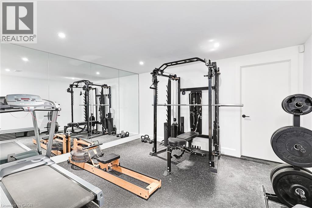 A well-equipped home gym with a variety of exercise machines and weights.