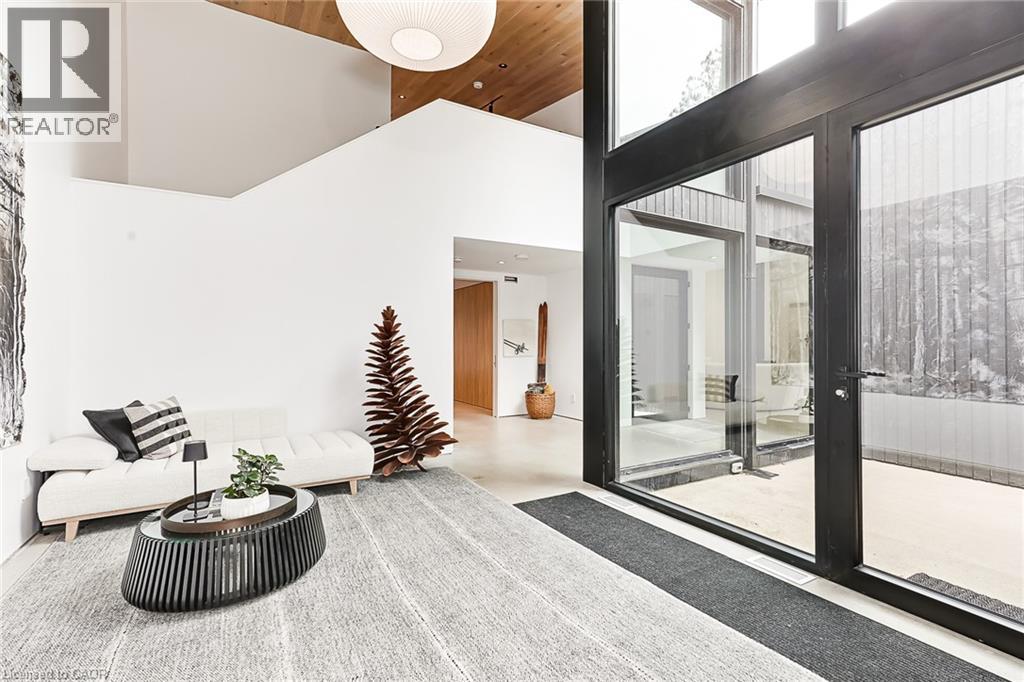 A modern living room with a white sofa and a glass door leading to a balcony.