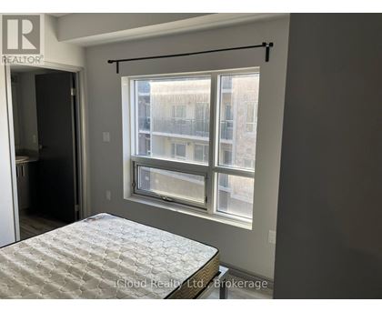 A bedroom with a bed and a window overlooking a building.