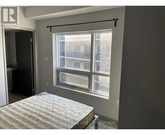 A bedroom with a bed and a window overlooking a building.