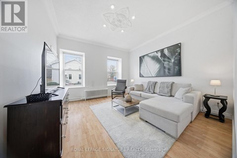 A living room with a white couch and a television.