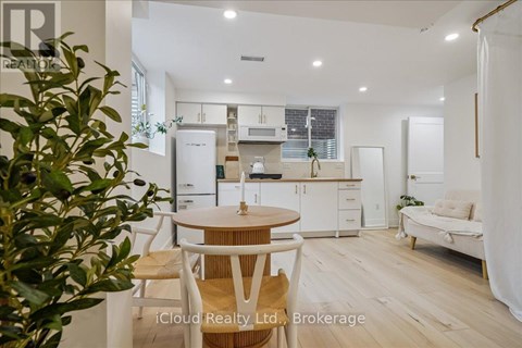 A modern kitchen with white cabinets and a wooden table.