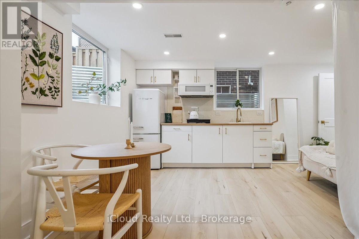 A modern kitchen with white cabinets and a wooden table.