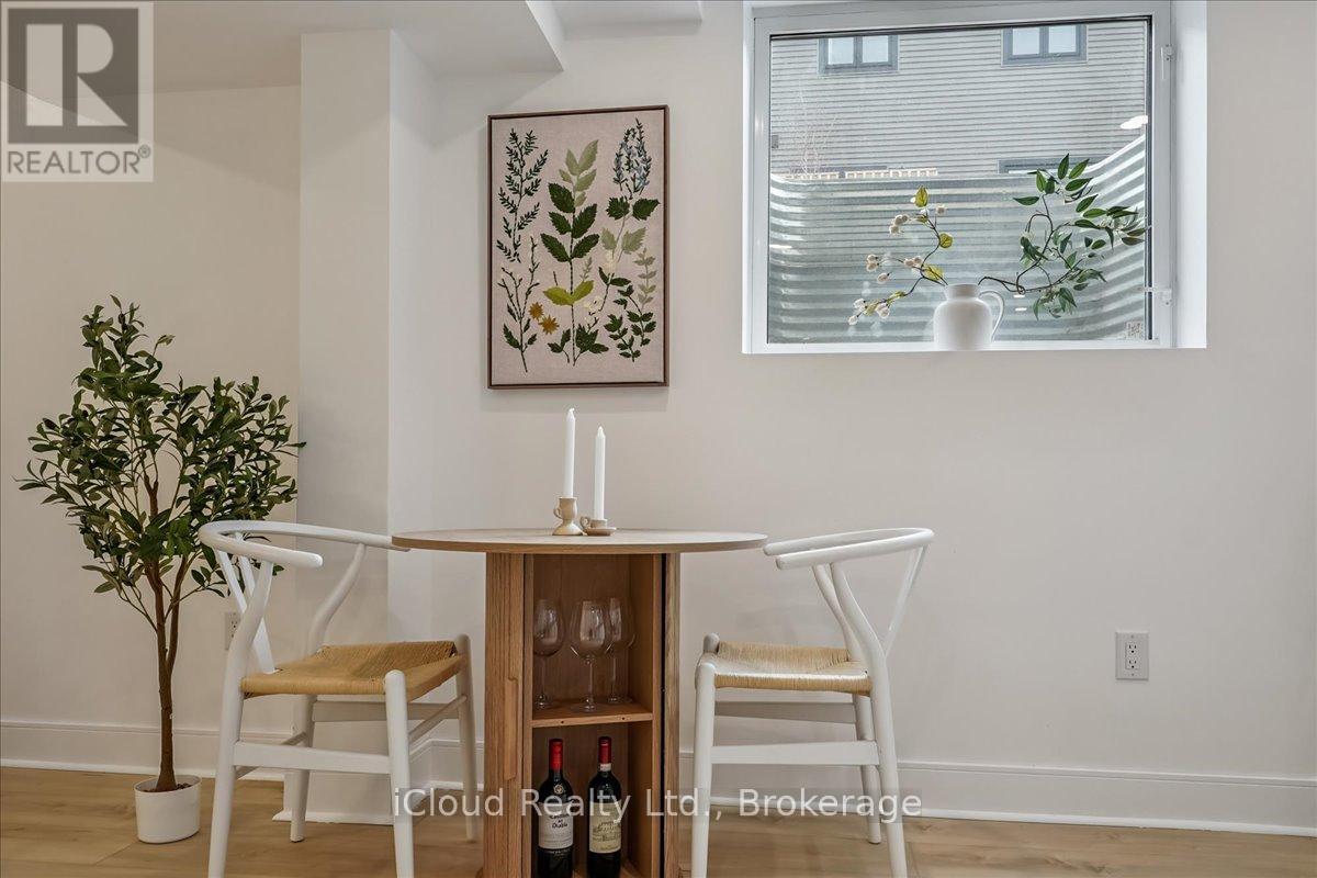 A dining room with a table, chairs and a painting on the wall.