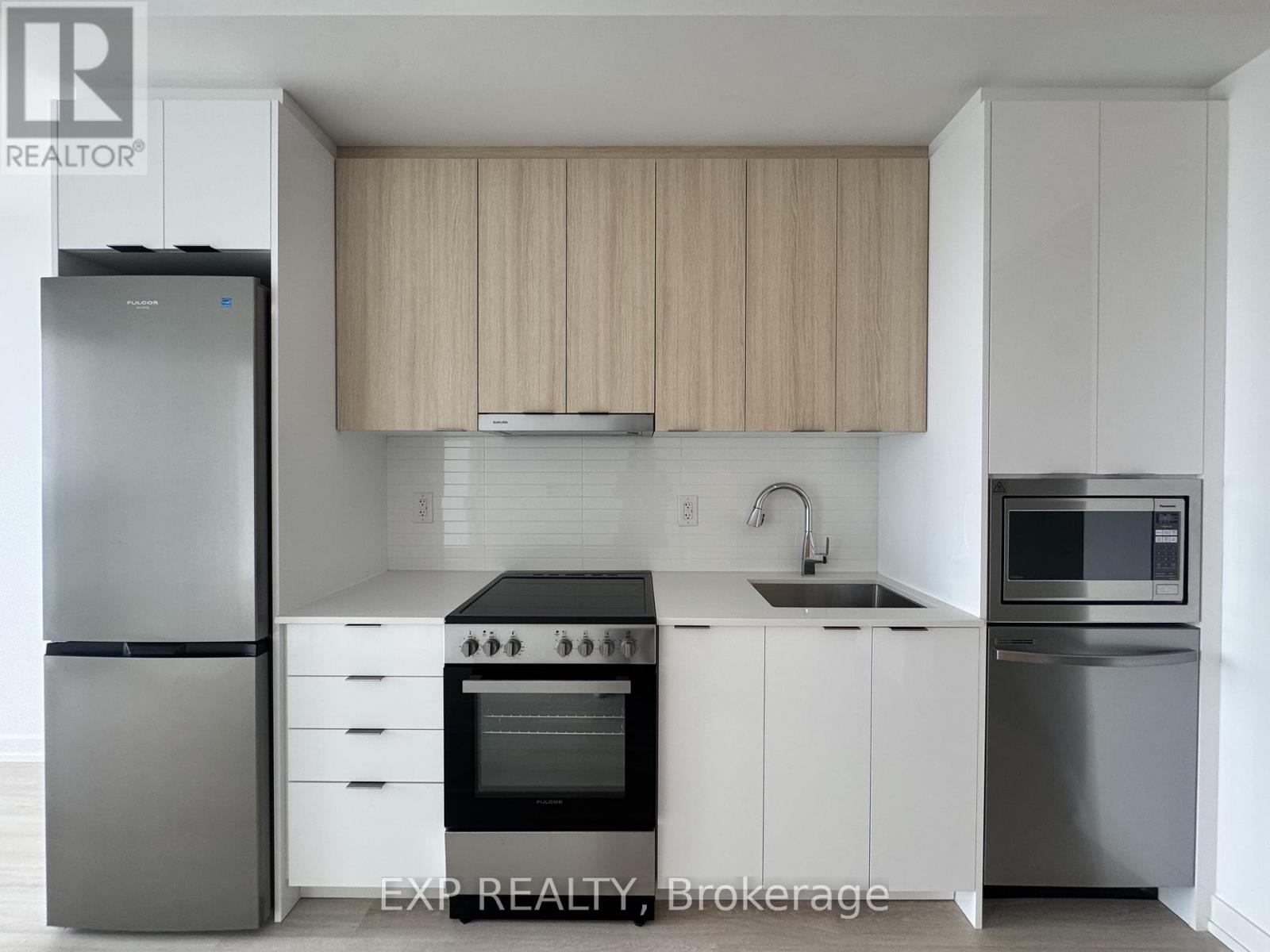 A modern kitchen with white cabinets and stainless steel appliances.