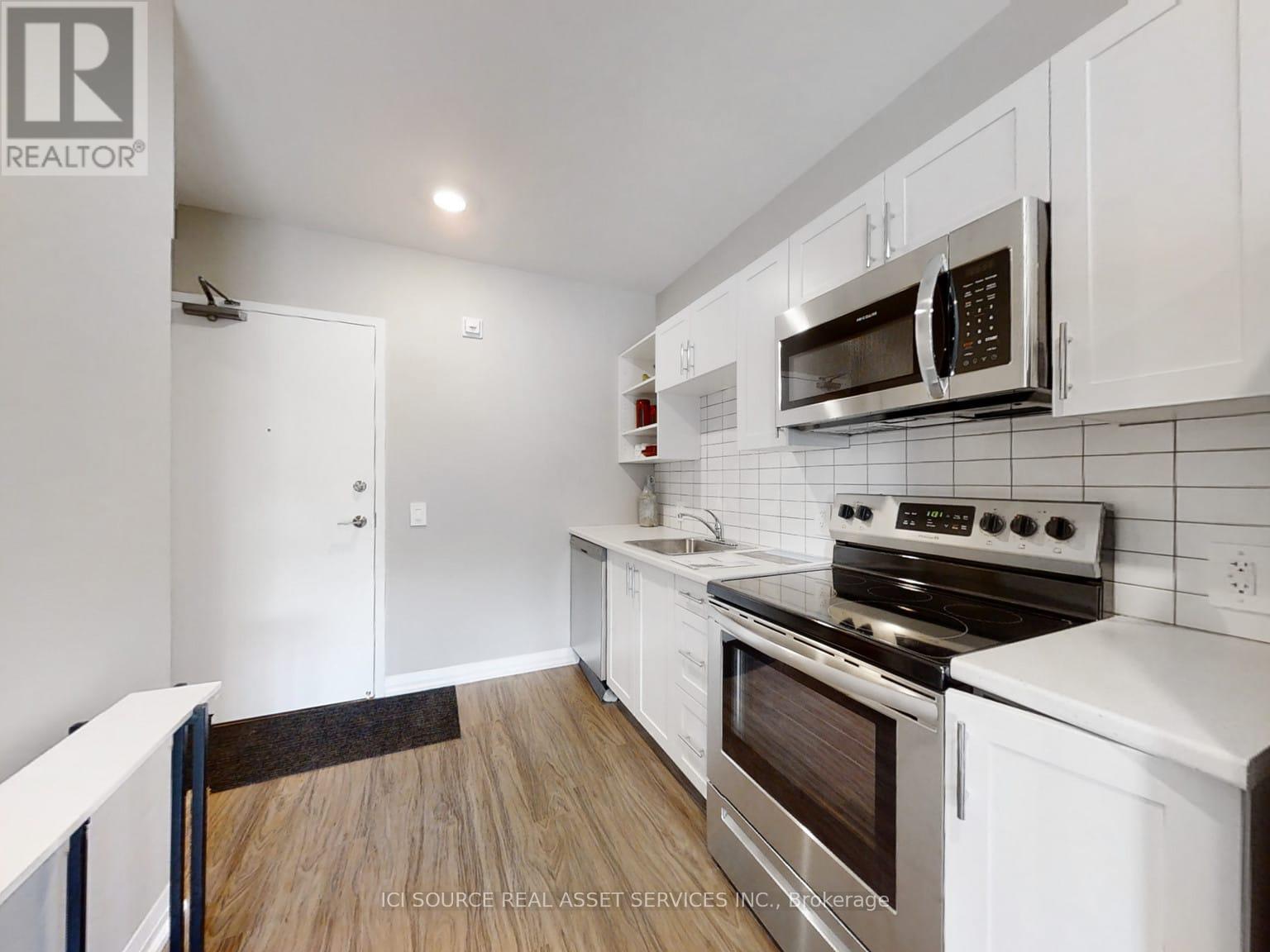 A kitchen with white cabinets and black appliances.