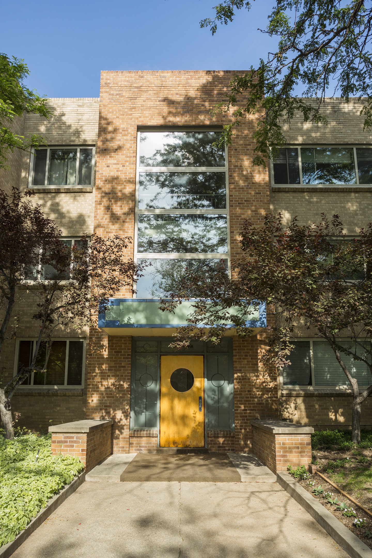 the front of a brick building with a yellow door