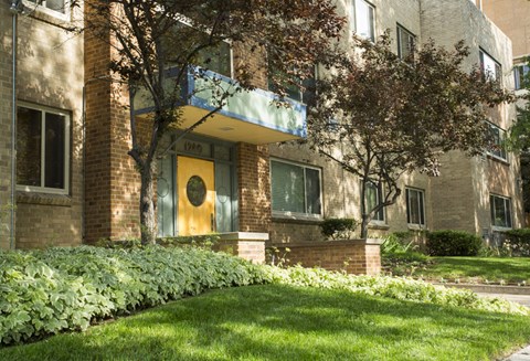 the front of a brick apartment building with a yellow door