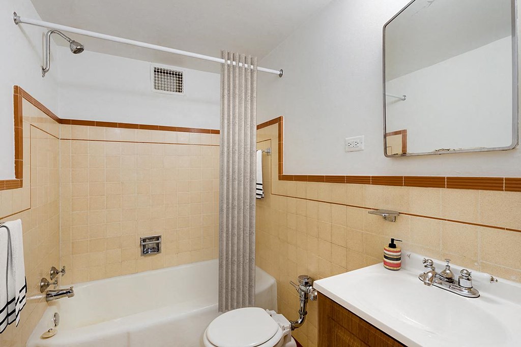 a bathroom with a shower and a toilet and a sink