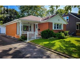 A red brick house with a white fence in front.
