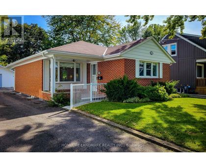 A red brick house with a white fence in front.