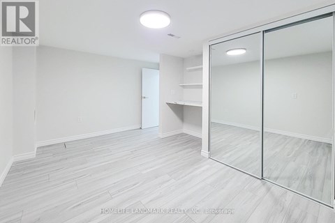 A room with a sliding glass door and wood flooring.