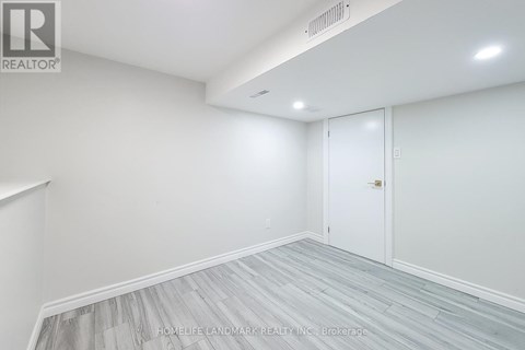 A room with a white door and a grey floor.