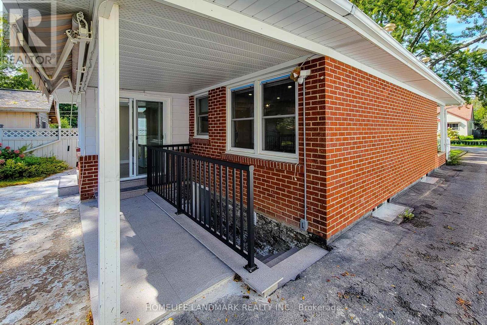 A small red brick house with a porch.