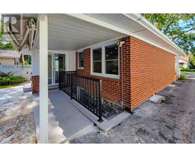 A small red brick house with a porch.