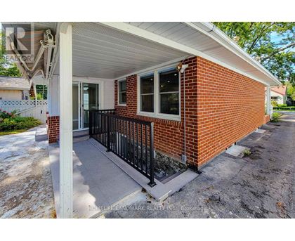 A small red brick house with a porch.