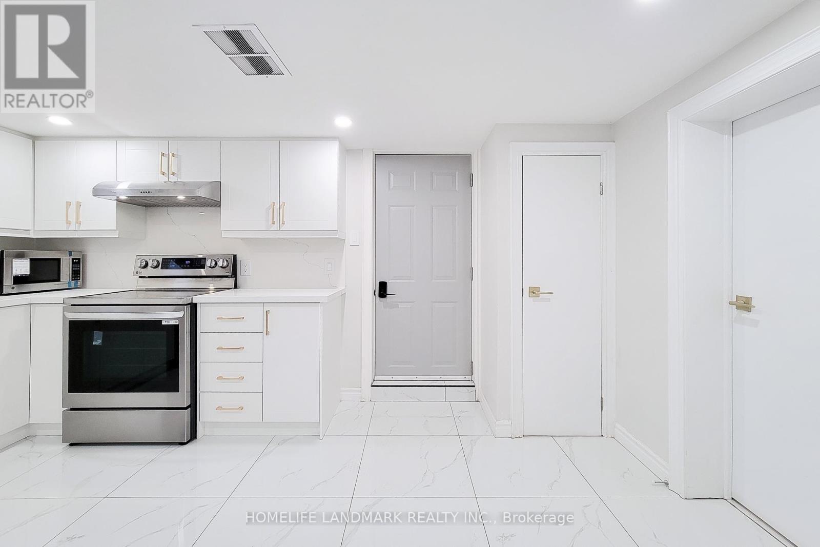 A white kitchen with a stainless steel oven and white cabinets.