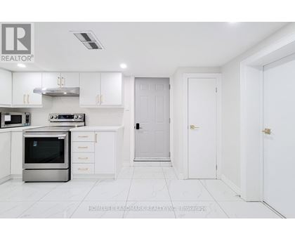 A white kitchen with a stainless steel oven and white cabinets.