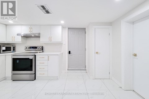 A white kitchen with a stainless steel oven and white cabinets.