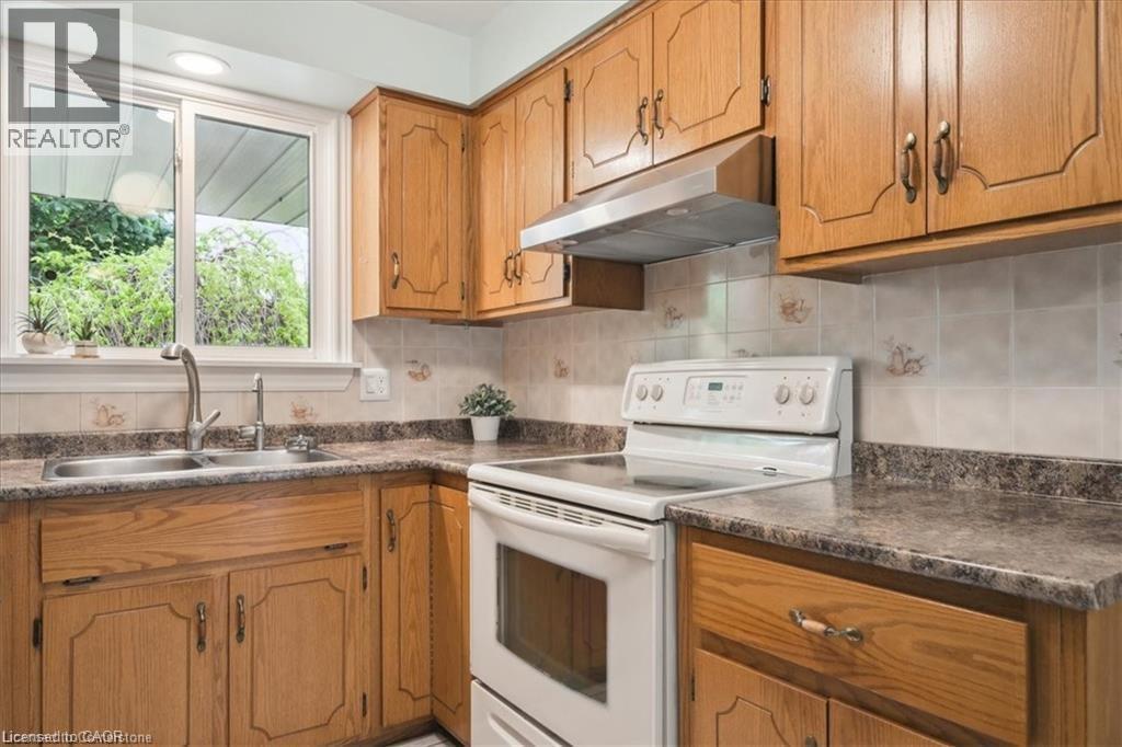 A kitchen with wooden cabinets and a white stove top oven.