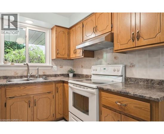 A kitchen with wooden cabinets and a white stove top oven.