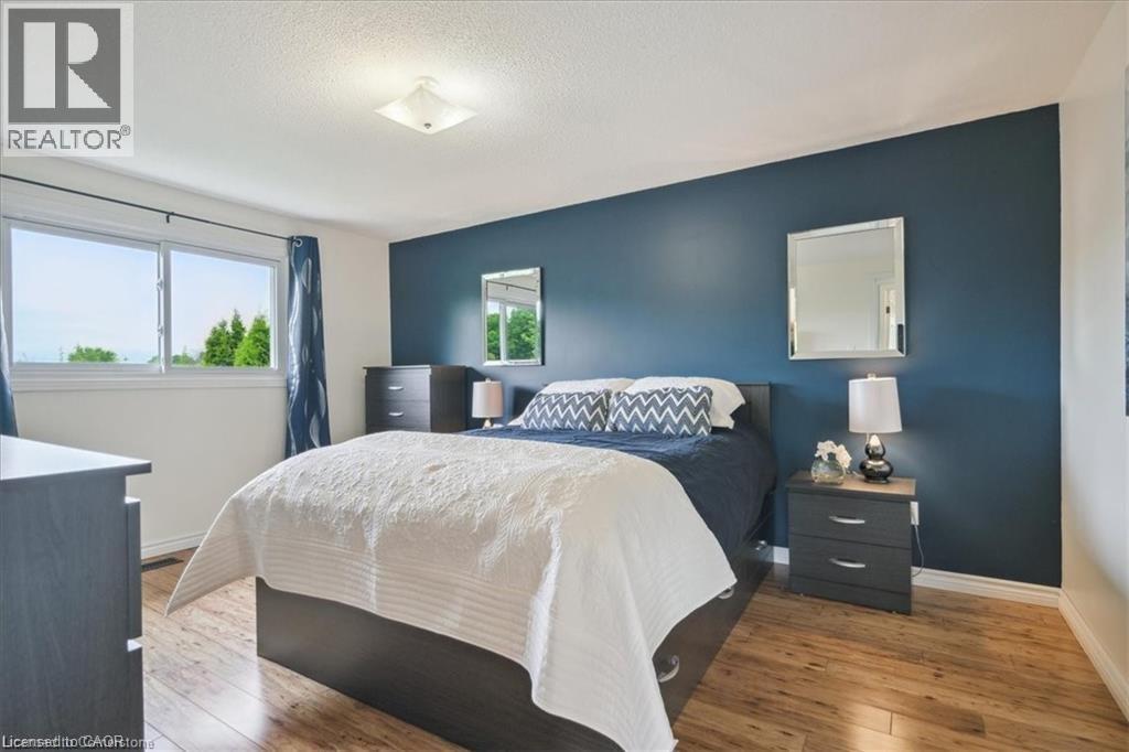 A bedroom with a bed, nightstands, and a dresser.