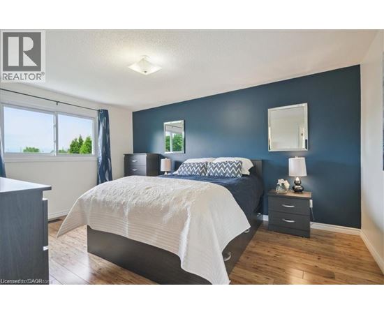 A bedroom with a bed, nightstands, and a dresser.