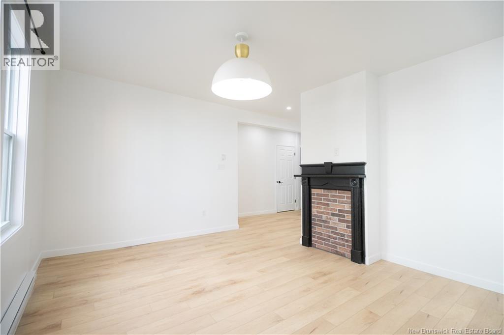 A room with a fireplace and wooden floors.
