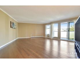 A spacious room with wooden floors and a large window.