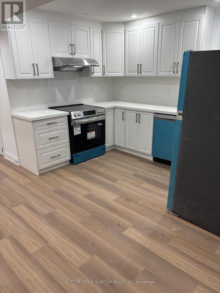 A kitchen with white cabinets and a black refrigerator.