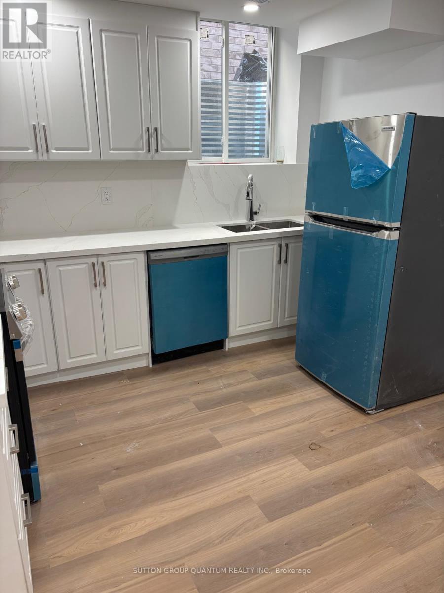 A kitchen with a blue refrigerator and white cabinets.