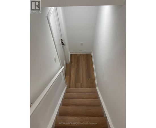 A staircase with wooden steps and white walls.
