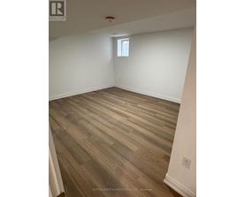 A room with wooden flooring and a window.
