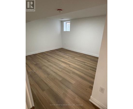 A room with wooden flooring and a window.