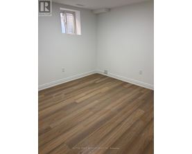 A room with wooden flooring and a window.