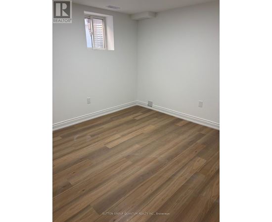 A room with wooden flooring and a window.