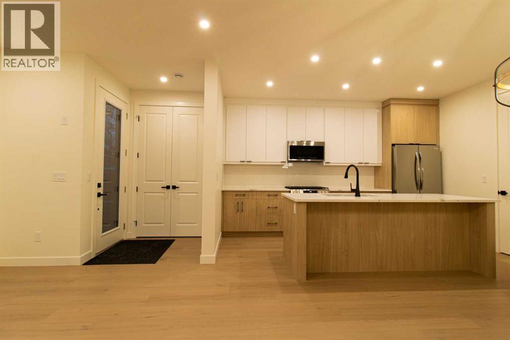 A modern kitchen with wooden cabinets and a black mat on the floor.