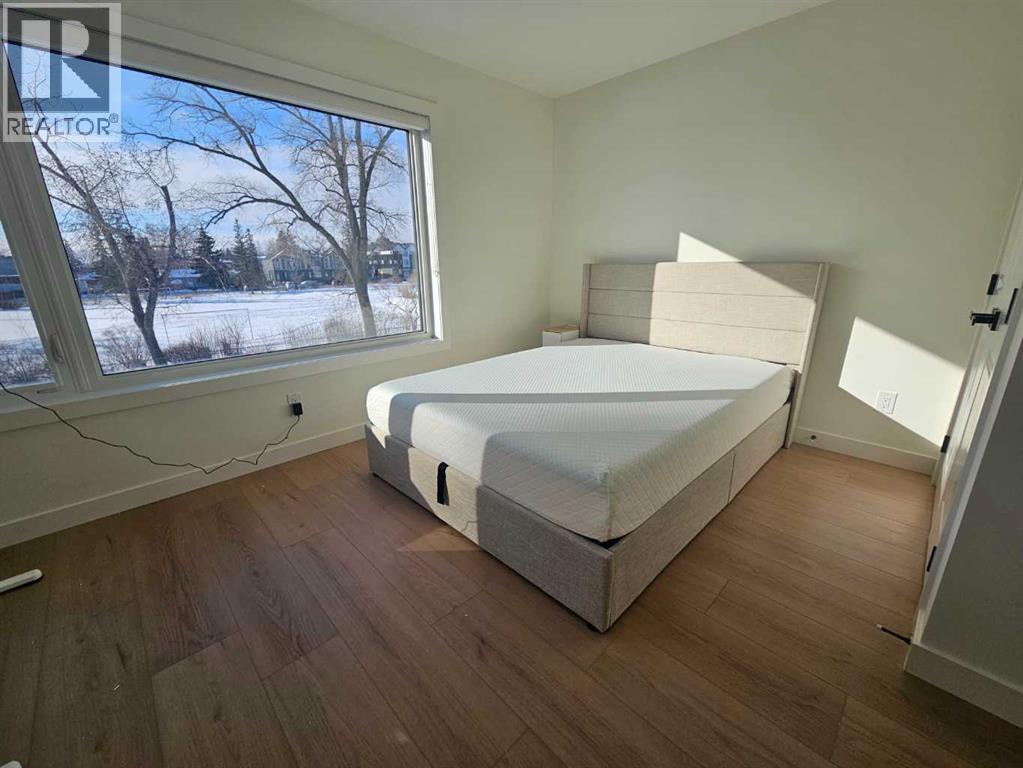 A bedroom with a large bed and a window showing a snowy landscape outside.
