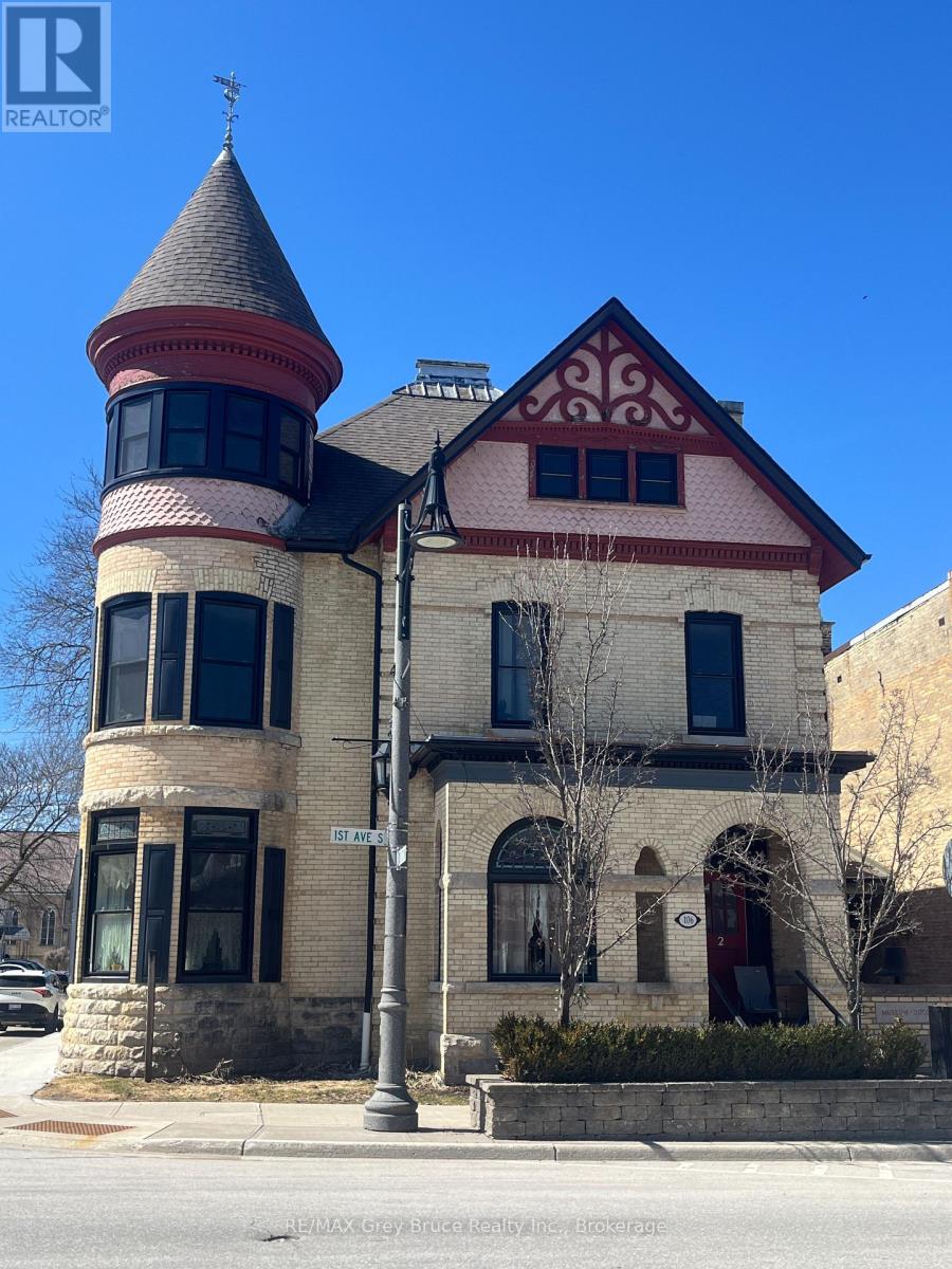 A house with a red and white facade and a tower.