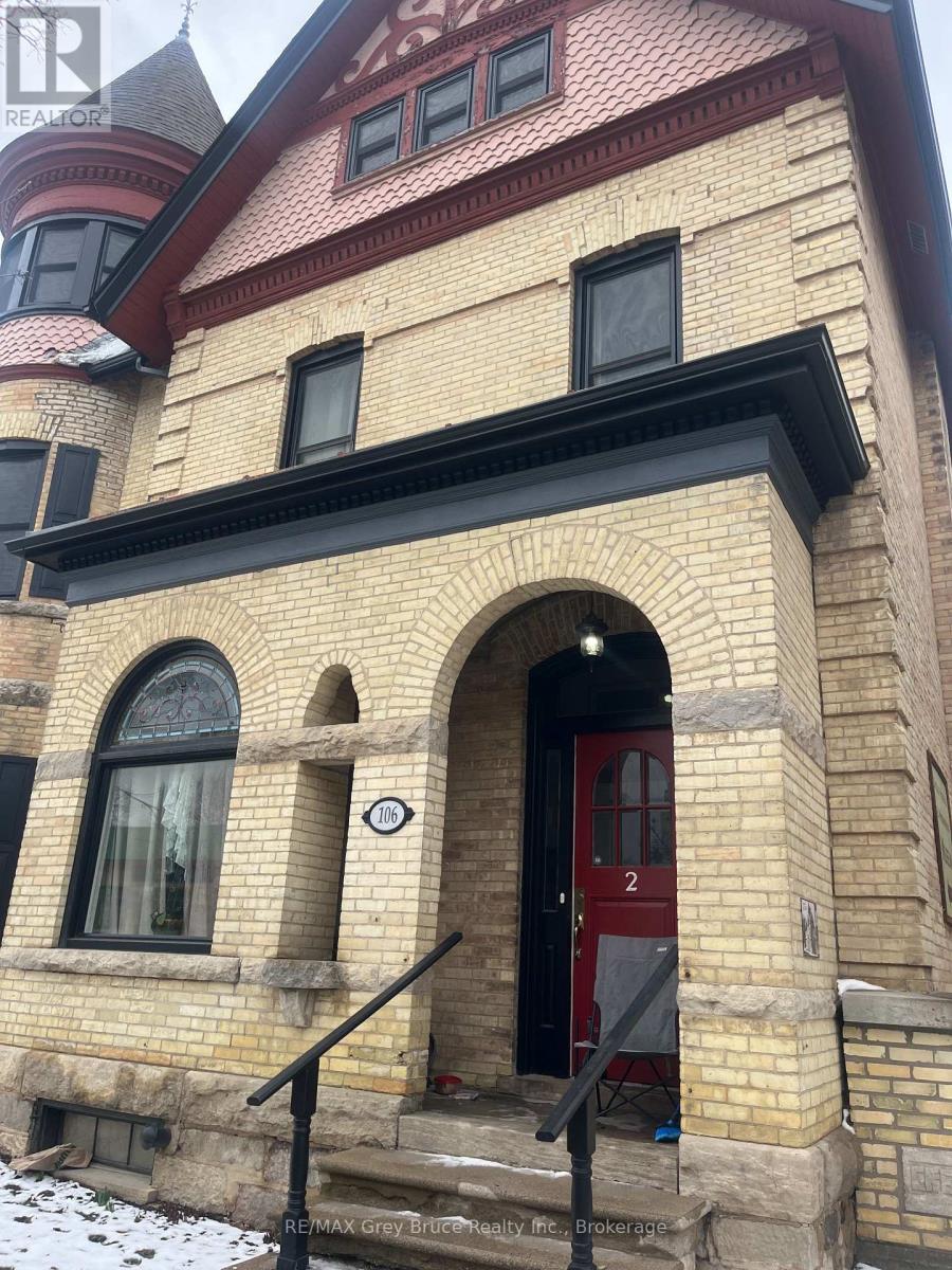 A house with a red door and a sign that says 2 on it.