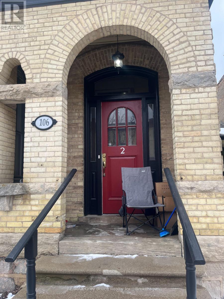 A red door with a sign that says 106 on the left.