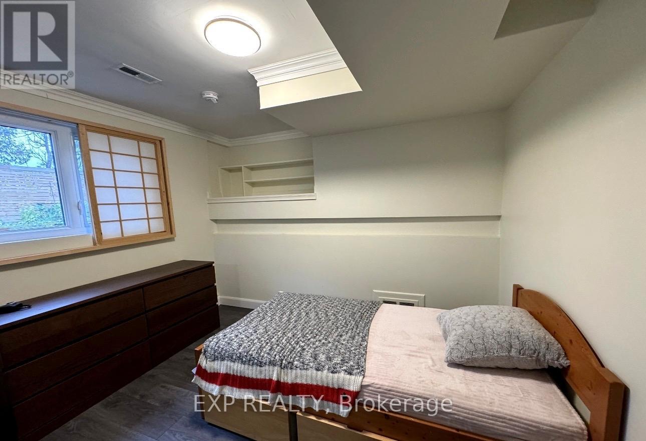 A bedroom with a bed, nightstand, and window.