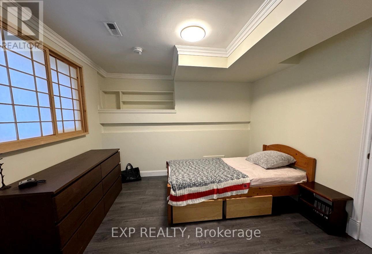 A bedroom with a bed, dresser, and window.