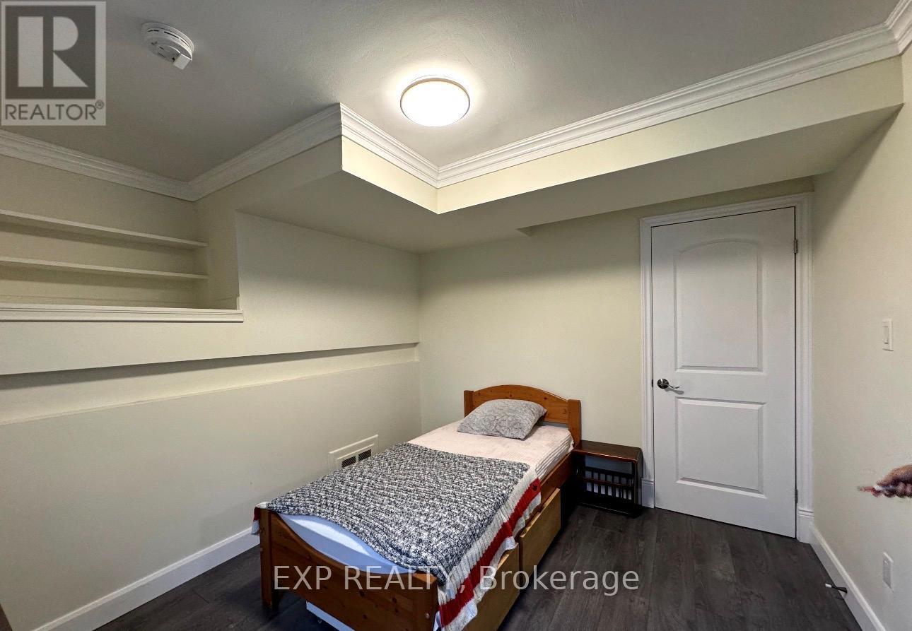 A bedroom with a bed, nightstand, and a door.