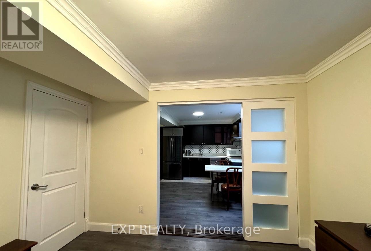 A white door with a glass panel in the middle leading to a dark room.