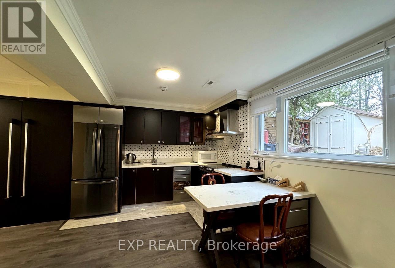 A kitchen with dark wood cabinets and a stainless steel refrigerator.