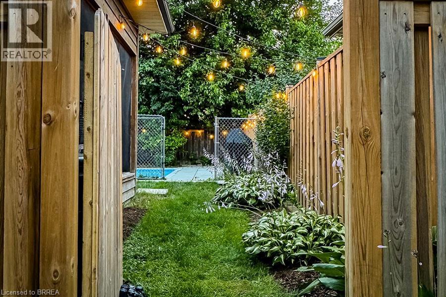 A backyard with a pool and a wooden fence.