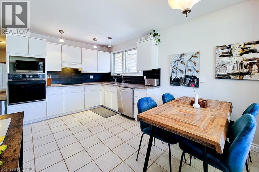 A kitchen with a table and chairs in the foreground and a countertop with a plant on it.
